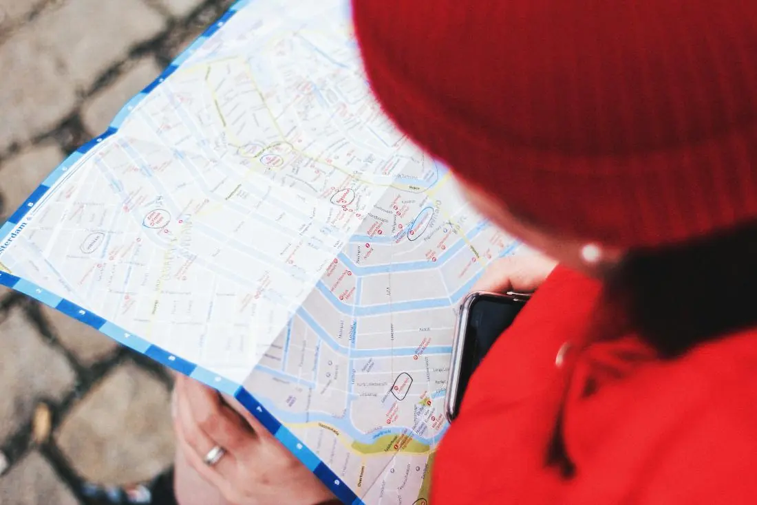 A person holding a smartphone over a city map