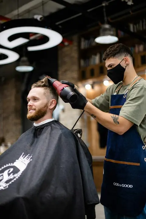 A barber styling a client's hair