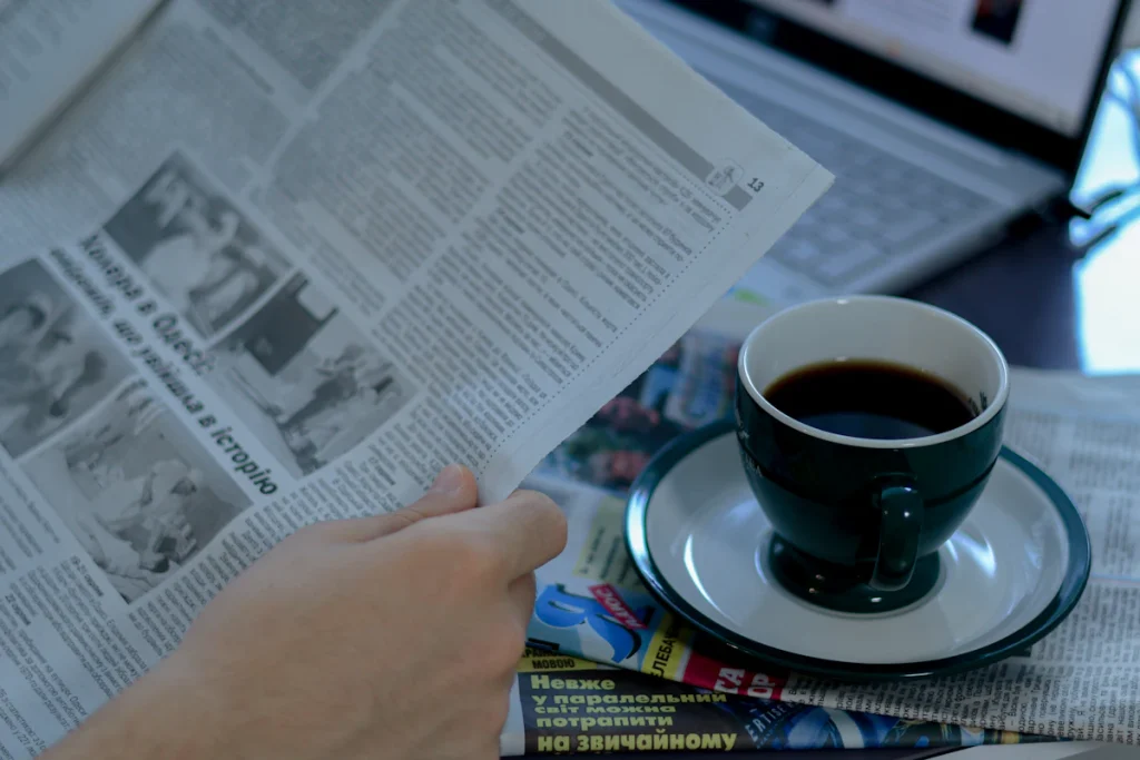 Man reading the morning newspaper over a cup of coffee, the kind of press coverage HARO link building aims for