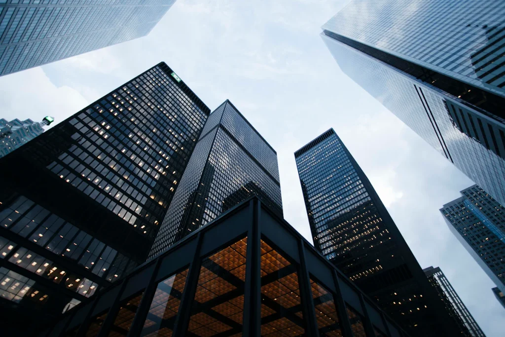 Looking up at tall glass skyscrapers against a blue sky, a visual for the skyscraper link building technique