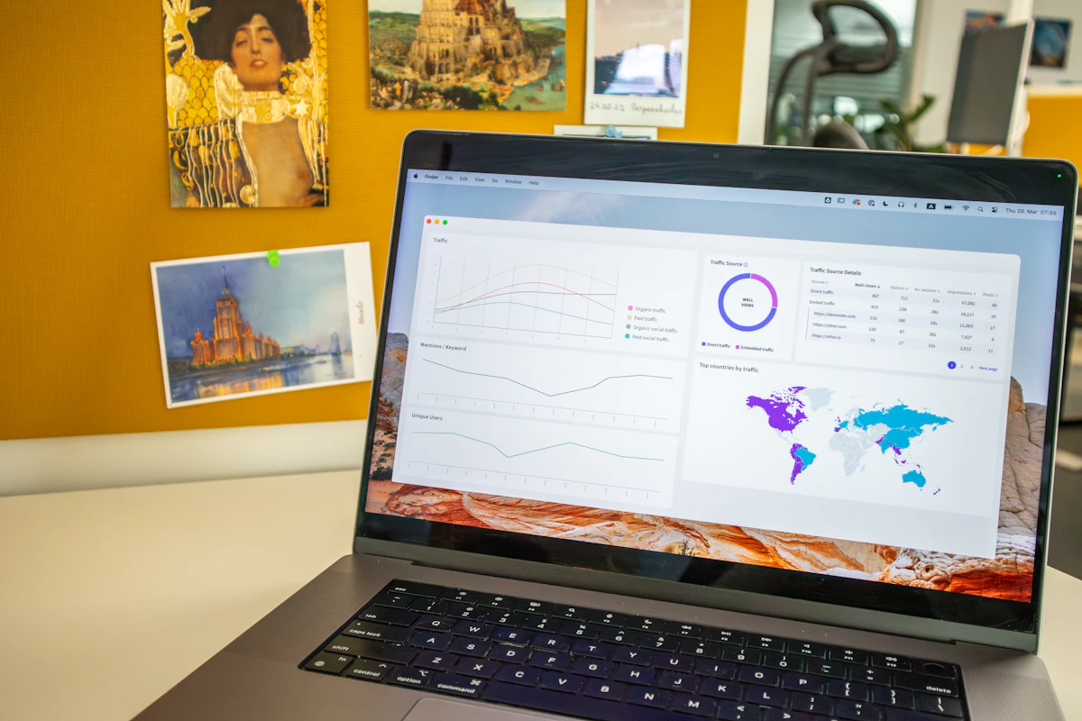 Laptop on an office desk showing social media analytics charts and engagement stats